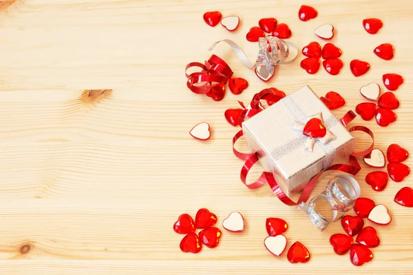 Caja de regalo de plata, cintas, corazones de San Valentín sobre un fondo de madera — Foto de Stock