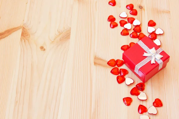 Red gift box and small valentine's hearts — Stock Photo, Image