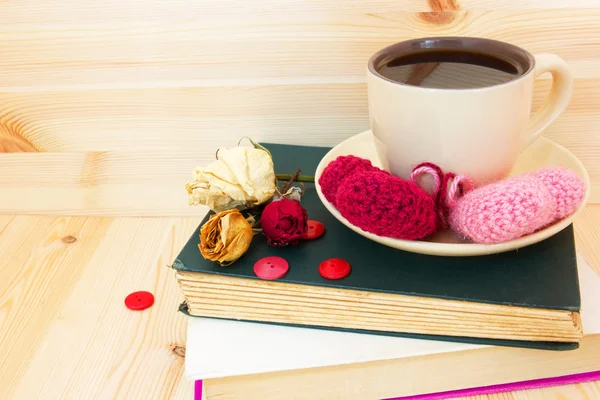 Xícara aconchegante de café quente e corações de malha — Fotografia de Stock