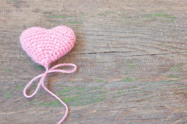 Coeur de Saint-Valentin rose tricoté sur une vieille texture de bois fissurée — Photo