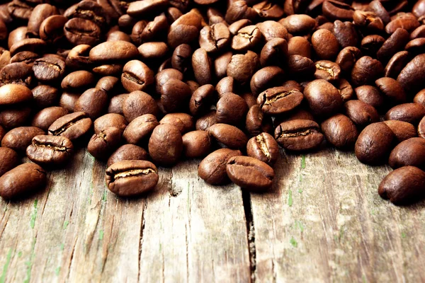Palonych ziaren kawy na tle drewniany gród — Zdjęcie stockowe
