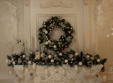 Noel çelengi ve oyuncaklarla süslenmiş şöminesi olan bir duvar parçası. Fotoğraf stüdyosundaki bir duvar.