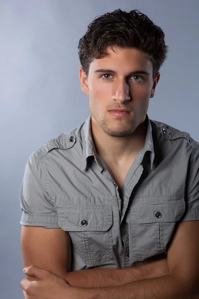 Sexy confident guy in studio on grey background — Stock Photo, Image