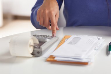 Cute Hispanic female paying bills