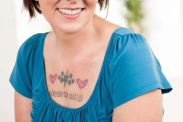 Pretty woman with tatoo "celebrate the good life" — Stock Photo, Image