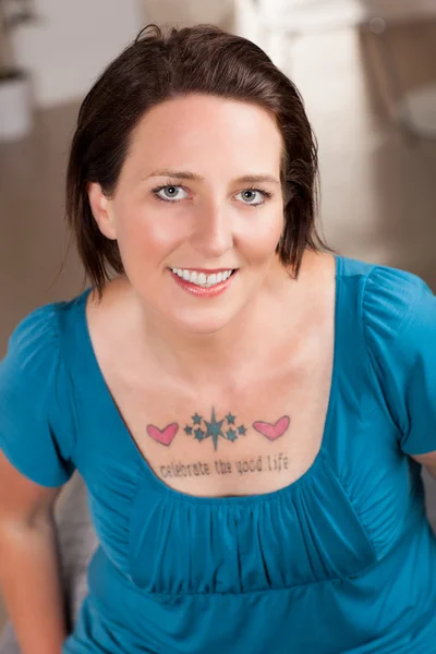 Vacker kvinna med tatuering "fira det goda livet" — Stockfoto