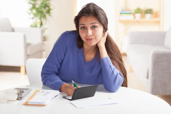 Cute Hispanic female paying bills Stock Picture