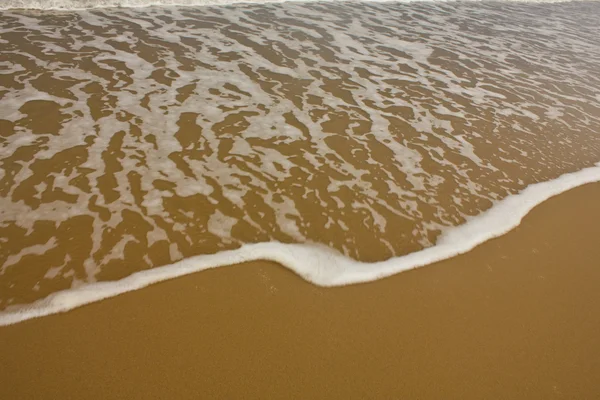 Блестящая тропическая морская волна на золотом песке — стоковое фото
