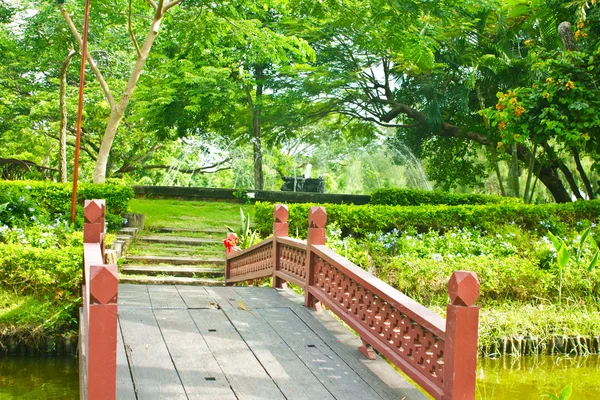 Schöne alte Holzbrücke im Park im Sommer. — Stockfoto