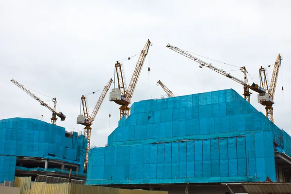 Es zeigt Baukräne und unfertiges Haus auf der Skyline — Stockfoto