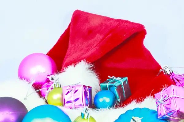 Bonito chapéu de Natal, presentes e bolas de Natal nas costas brancas — Fotografia de Stock