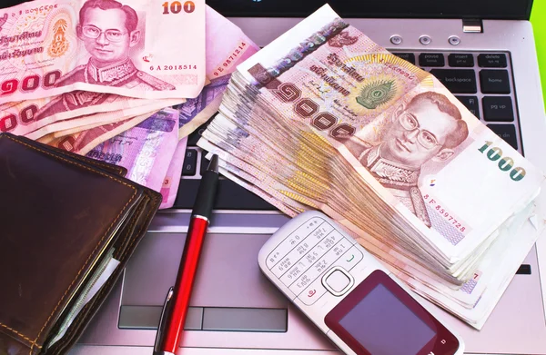 Close up van 1000 baht bankbiljetten en mobiele telefoon op Opmerking boek — Stockfoto