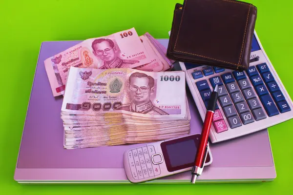 Close up of 1000 baht banknotes and calculator on note book — Stock Photo, Image