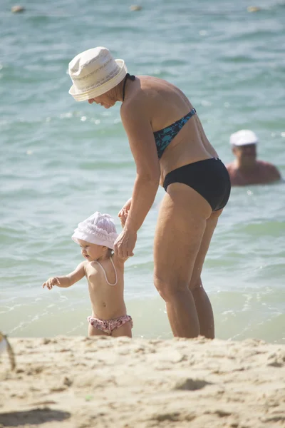 Grootmoeder en kleindochter wandelen op het strand — Stockfoto