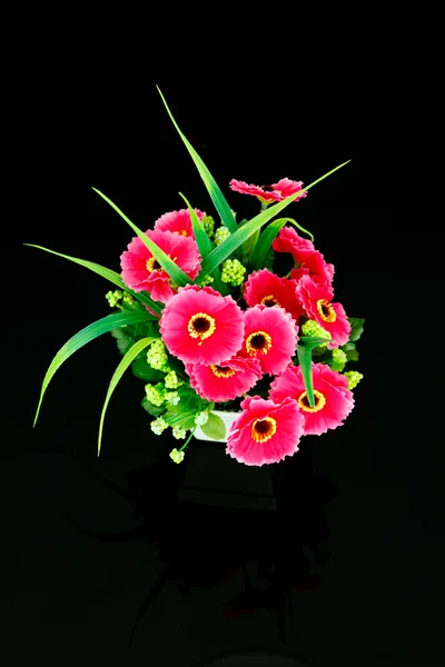 Fausses fleurs dans le vase sur fond noir — Photo