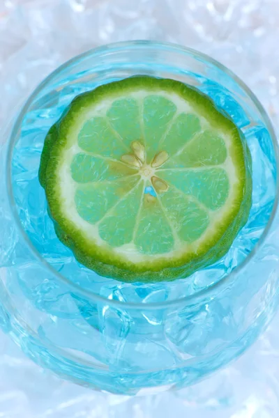 Glass of blue cocktail with lime on white background — Stock Photo, Image