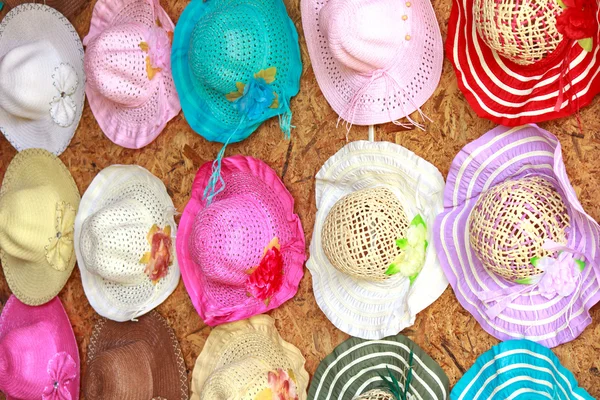 Set of straw woven hats with colorful ribbons in a row — Stock Photo, Image