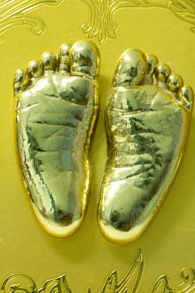 Золотой отпечаток ноги маленького ребенка в гипсе — стоковое фото