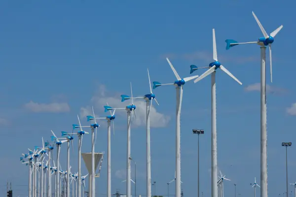 Szereg generatorów wiatrowych mocy w jasne tło niebieskie niebo. — Zdjęcie stockowe