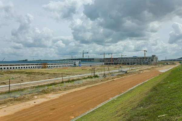 It shows construction cranes and unfinished house on the skylin — Stock Photo, Image