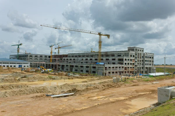 It shows construction cranes and unfinished house on the skylin — Stock Photo, Image