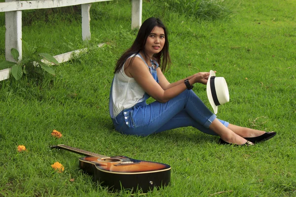 Blick auf eine schöne junge Landmädchen mit einer Gitarre — Stockfoto