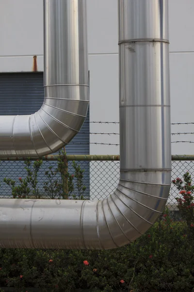 Zona industrial, tuberías de acero y válvulas contra el cielo azul — Foto de Stock