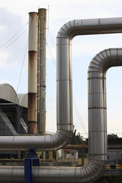 Zona industrial, tuberías de acero y válvulas contra el cielo azul — Foto de Stock