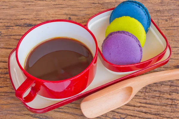 Red cup of coffee and colorful Biscuit on wooden table backgroun — Stock Photo, Image