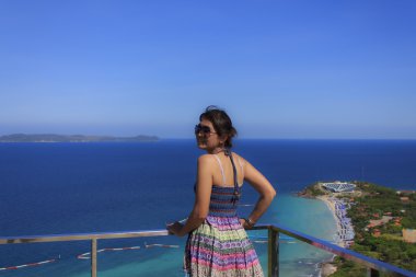 güzel bir kız ayakta ve denize doğru bakarak Giydir