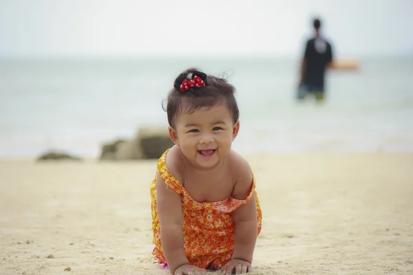 Asiatisches Baby lächelt auf Sand am Strand — Stockfoto