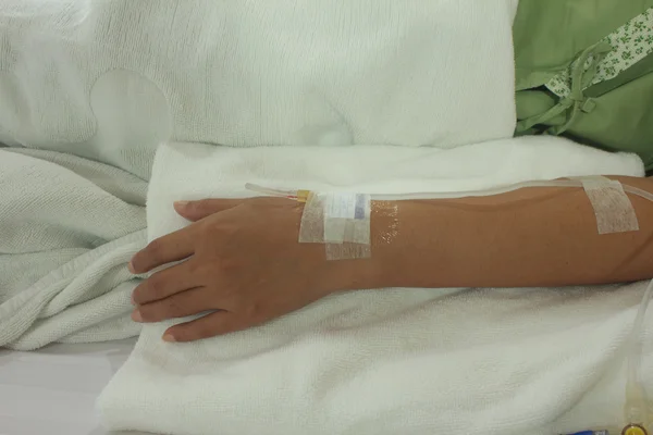 Mão do paciente com um gotejamento intravenoso antes da cirurgia em um ope — Fotografia de Stock