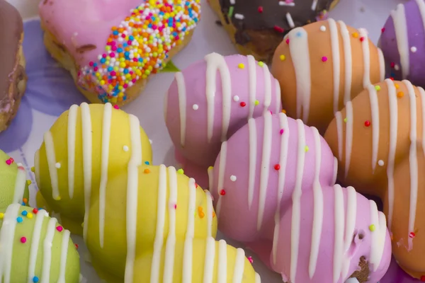 Bunte und leckere Donuts auf weißem Hintergrund — Stockfoto