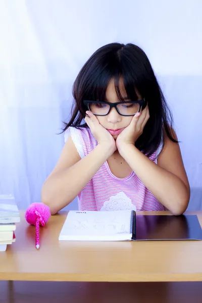 Retrato de alegre menina asiática fazendo sua lição de casa — Fotografia de Stock