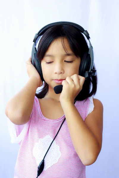 Asie dívka, která nosí sluchátka na bílém pozadí — Stock fotografie