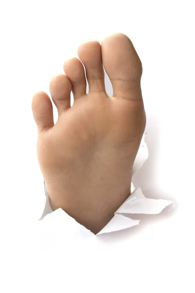 Foot with thumb up through a hole in paper — Stock Photo, Image