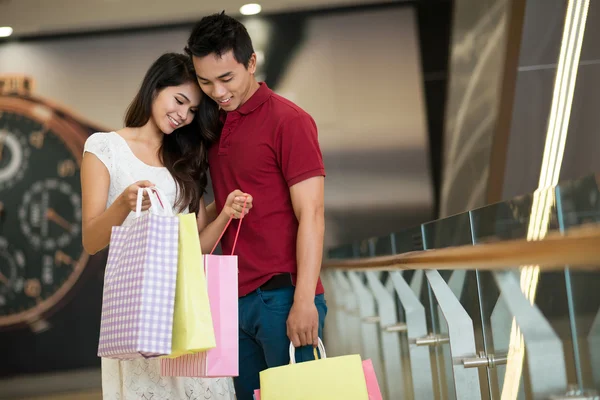 Asiático hombre y mujer de pie y mirando en una bolsa de compras — Foto de Stock