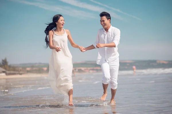 Casal correndo em uma praia — Fotografia de Stock