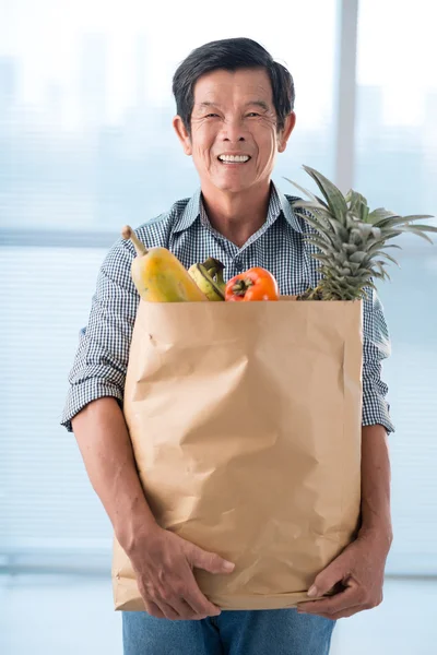 Homem sênior com um saco de papel — Fotografia de Stock