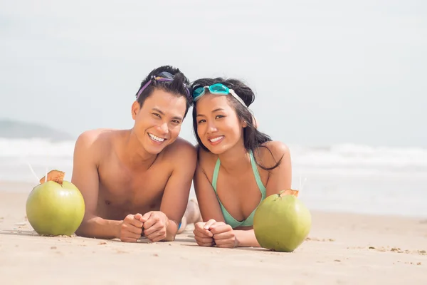 Pareja alegre tumbada en la playa — Foto de Stock