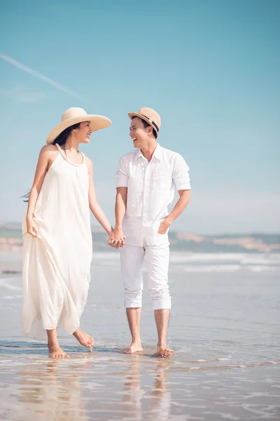 해변을 걷고 있는 젊은 부부 — 스톡 사진