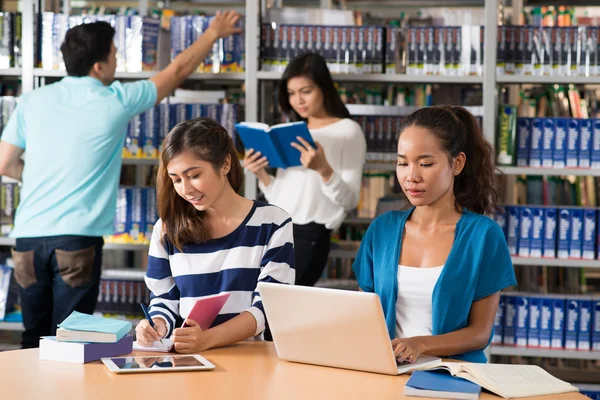 Adolescentes na biblioteca — Fotografia de Stock