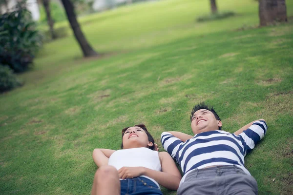 Couple lying on green grass — Stock Photo, Image