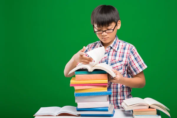 Menino procurando informações nos livros — Fotografia de Stock