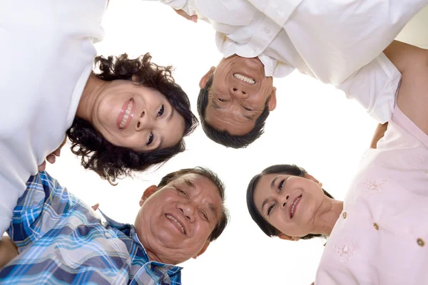 Senior friends standing in a huddle — Stock Photo, Image