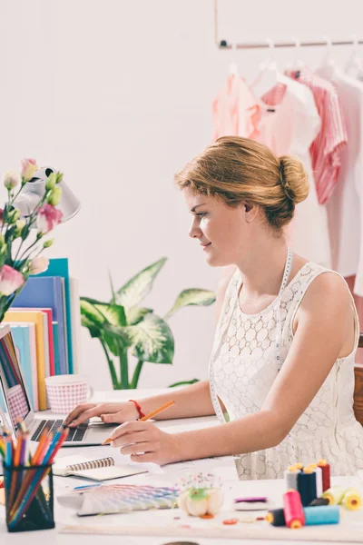 Woman tailor working on the laptop — Stock Photo, Image