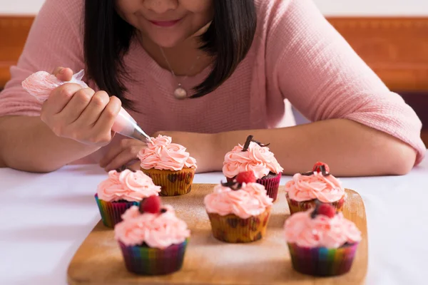 Mujer disfrutando cocinando cupcakes —  Fotos de Stock