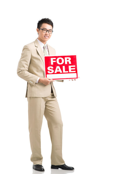 Estate agent holding for sale signboard