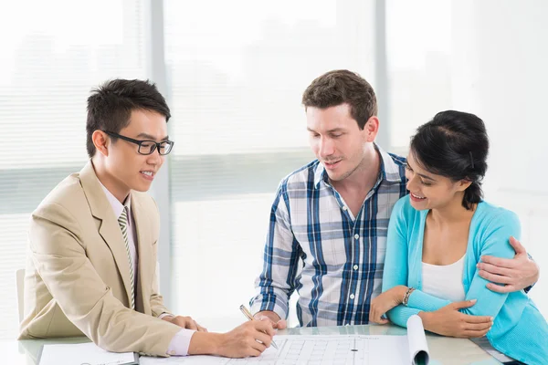 Gezin dat overleg met een onroerende goederenagent — Stockfoto