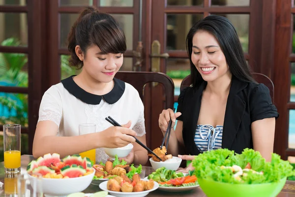 Mor och dotter doppa kött bitar — Stockfoto